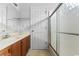 Bright bathroom features a wooden vanity with a modern frosted glass shower and white door at 401 Barton Loop, Myrtle Beach, SC 29579