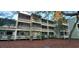 Three-story condo building with multiple screened-in porches and lush landscaping at 415 Ocean Creek Dr. # 2159, Myrtle Beach, SC 29572