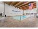 Bright indoor pool area featuring exposed wood ceiling, brick floor, and American flag decor at 415 Ocean Creek Dr. # 2159, Myrtle Beach, SC 29572