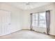 Bright bedroom featuring neutral carpet, ceiling fan, and natural light from double windows with decorative curtains at 440 Woodpecker Ln. # A, Murrells Inlet, SC 29576