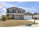 Two story brick home featuring a well manicured front lawn, a red front door, and attached garage at 445 Mooreland Dr., Myrtle Beach, SC 29588