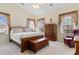 Bright bedroom featuring a wooden bed frame, dresser, and windows adorned with curtains offering ample natural light at 446 Deerfield Links Dr., Surfside Beach, SC 29575