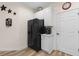 Modern kitchen featuring a black refrigerator, white cabinets, and wood-look vinyl flooring at 446 Deerfield Links Dr., Surfside Beach, SC 29575