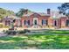 Elegant brick home with a manicured lawn, stunning front facade, and striking eagle statue in the front yard at 474 Wraggs Ferry Rd., Georgetown, SC 29440