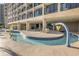 Fun outdoor pool area featuring a shallow, winding pool with colorful play features and plenty of seating at 4800 S Ocean Blvd. # 1514, North Myrtle Beach, SC 29582