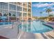 A stunning outdoor pool area with clear blue water, poolside seating, and building views with palm trees at 4800 S Ocean Blvd. # 1514, North Myrtle Beach, SC 29582