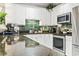 Bright kitchen featuring white cabinets, dark countertops, stainless steel appliances and pendant lighting at 4817 Magnolia Lake Dr. # 104, Myrtle Beach, SC 29577