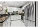 Modern kitchen with stainless steel refrigerator, white cabinets, and tile floors, creating a spacious and efficient area at 4817 Magnolia Lake Dr. # 104, Myrtle Beach, SC 29577