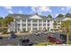 Exterior view of three story condo complex with ample parking spaces and manicured greenery at 5060 Windsor Green Way # 304, Myrtle Beach, SC 29579