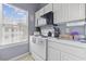 Galley kitchen features white appliances and cabinets plus a window for natural light at 5060 Windsor Green Way # 304, Myrtle Beach, SC 29579