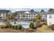 Aerial view of a community pool, surrounded by landscaping and parking, adjacent to a multi-story building at 5060 Windsor Green Way # 304, Myrtle Beach, SC 29579