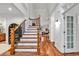 Elegant foyer with hardwood floors, staircase with iron balusters, and views into the living spaces at 52 Olde Canal Loop, Pawleys Island, SC 29585