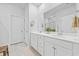 Well-lit bathroom with double sink vanity, white cabinets, and large mirror at 521 Harbison Circle, Myrtle Beach, SC 29579