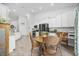 Open concept kitchen with stainless steel appliances, white cabinets, and a wooden dining table at 521 Harbison Circle, Myrtle Beach, SC 29579