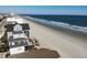 An aerial view of homes along the ocean coastline with a pier at 547 South Waccamaw Dr., Garden City Beach, SC 29576