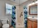 Full bathroom featuring a shower with colorful fish-themed curtain, a toilet and a sink and vanity at 547 South Waccamaw Dr., Garden City Beach, SC 29576