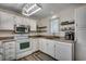 Well-lit kitchen featuring white cabinetry, stainless steel appliances, and neutral countertops at 547 South Waccamaw Dr., Garden City Beach, SC 29576