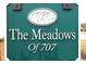 Sign for The Meadows of 707 community with a decorative emblem featuring grass in an oval frame at 583 Meadowgrass Ct., Myrtle Beach, SC 29588