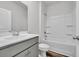 Bright bathroom featuring a shower-tub combo and modern sink with gray cabinetry at 609 Gryffindor Dr., Longs, SC 29568