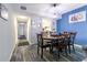 Dining room with a round wooden table and six chairs, laminate flooring, and vibrant blue accent wall at 7603 N Ocean Blvd. # 4E, Myrtle Beach, SC 29572