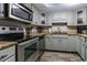 Galley kitchen with stainless steel appliances, light wood cabinets, and wood laminate flooring at 7603 N Ocean Blvd. # 4E, Myrtle Beach, SC 29572