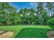 Lush backyard with green grass and a tranquil pond view, surrounded by trees, offering privacy at 8545 Hopkins Circle # G, Myrtle Beach, SC 29575