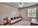 Well-lit bedroom with a daybed, a ceiling fan, and a large window overlooking greenery at 8545 Hopkins Circle # G, Myrtle Beach, SC 29575