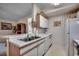 Well-lit kitchen with white cabinets, a stainless steel sink, and views into the living area at 8545 Hopkins Circle # G, Myrtle Beach, SC 29575