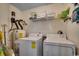 Functional laundry room with a washer, dryer, water heater, and shelving for storage at 8545 Hopkins Circle # G, Myrtle Beach, SC 29575