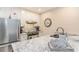 Bright kitchen with white cabinets, stainless steel refrigerator, granite counters, and white subway tile backsplash at 88 Salt Marsh Circle # 22C, Pawleys Island, SC 29585