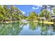 Scenic pond view with fountain, lush greenery, and blue sky enhances the property's tranquil setting at 88 Salt Marsh Circle # 22C, Pawleys Island, SC 29585