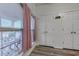 Bright hallway with wood floors and a view of a sunny porch through a large window with curtains at 920 Leather Leaf Ln., Longs, SC 29568