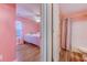 Hallway view into pink bedroom featuring wood floors, with an adjacent bathroom for added convenience at 920 Leather Leaf Ln., Longs, SC 29568