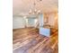 Open-concept living area with wood floors, a chandelier, and a breakfast bar overlooking the stairs at 920 Leather Leaf Ln., Longs, SC 29568