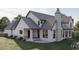 Rear view of home highlighting covered porch, stone chimney, manicured lawn, and architectural details at 9413 Park St., Myrtle Beach, SC 29572