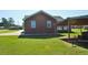 Backyard featuring a shelter structure, and back view of the home's brick exterior at 960 South Farr Ave., Andrews, SC 29510