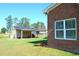 View of the brick home's backyard with a shed and shelter at 960 South Farr Ave., Andrews, SC 29510