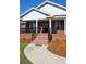 Inviting brick home featuring a welcoming front porch with black railings and a decorative front door at 960 South Farr Ave., Andrews, SC 29510