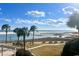 Breathtaking beach view showcasing the ocean, beach, palm trees, and seating area at 101 Ocean Creek Dr. # Jj-1, Myrtle Beach, SC 29572