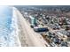 Expansive aerial view of a coastal neighborhood stretching along a pristine beach with high-rise resorts at 124 B Vista Dr., Murrells Inlet, SC 29576