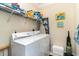 A full laundry room with white washer and dryer, wire shelving, and decorative artwork at 124 B Vista Dr., Murrells Inlet, SC 29576