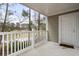 Inviting covered balcony with white railings offering serene views of the lush outdoor landscape at 125 South Shore Blvd. # 201, Longs, SC 29568