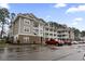 Apartment building featuring multiple balconies, stone accents, and ample parking on a partially cloudy day at 125 South Shore Blvd. # 201, Longs, SC 29568