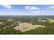 An aerial view shows this home located in a community built around a pond surrounded by lush green trees on a sunny day at 128 Caveson Way, Conway, SC 29526