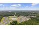 An aerial view shows this home located in a community built around a pond with lush green trees surrounding the neighborhood at 128 Caveson Way, Conway, SC 29526