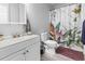 This bathroom features a white vanity, toilet, and a shower with a floral shower curtain at 1409 Highway 15 # 4, Myrtle Beach, SC 29577