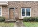 Charming townhome entrance with brick facade, decorative shutters, and a well-manicured garden at 1409 Highway 15 # 4, Myrtle Beach, SC 29577