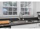 Kitchen sink with black countertops and modern fixtures; view to backyard through window at 1409 Highway 15 # 4, Myrtle Beach, SC 29577