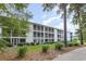 Multi-story condo building with screened porches, mature trees and green space at 1529 Lanterns Rest Dr. # 201, Myrtle Beach, SC 29579