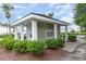 Charming exterior view of a light green outbuilding with white columns and neatly trimmed bushes at 1529 Lanterns Rest Dr. # 201, Myrtle Beach, SC 29579